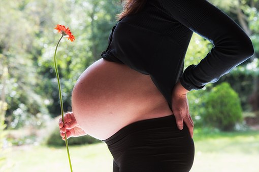 Gestante de perfil mostrando a barriga